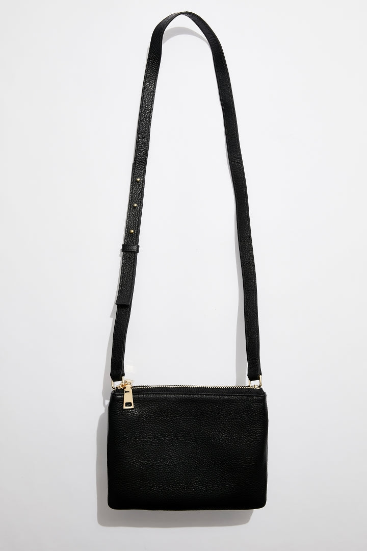 front view of MON Purses' double pouch bag in black pebbled leather with gold hardware with the long shoulder strap 