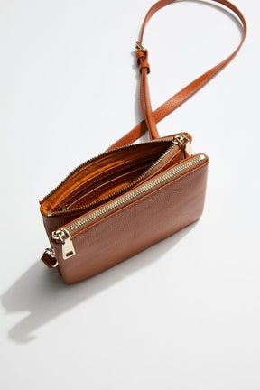 interior view of mon purses' double pouch bag in camel pebbled leather with gold hardware with long shoulder strap showing interior of one of the pouches