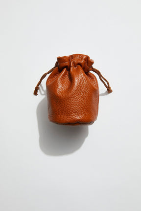 front view of mon purse's camel brown pebbled leather trinket pouch with drawstring closure