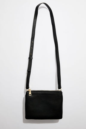 front view of MON Purses' double pouch bag in black pebbled leather with gold hardware with the long shoulder strap 
