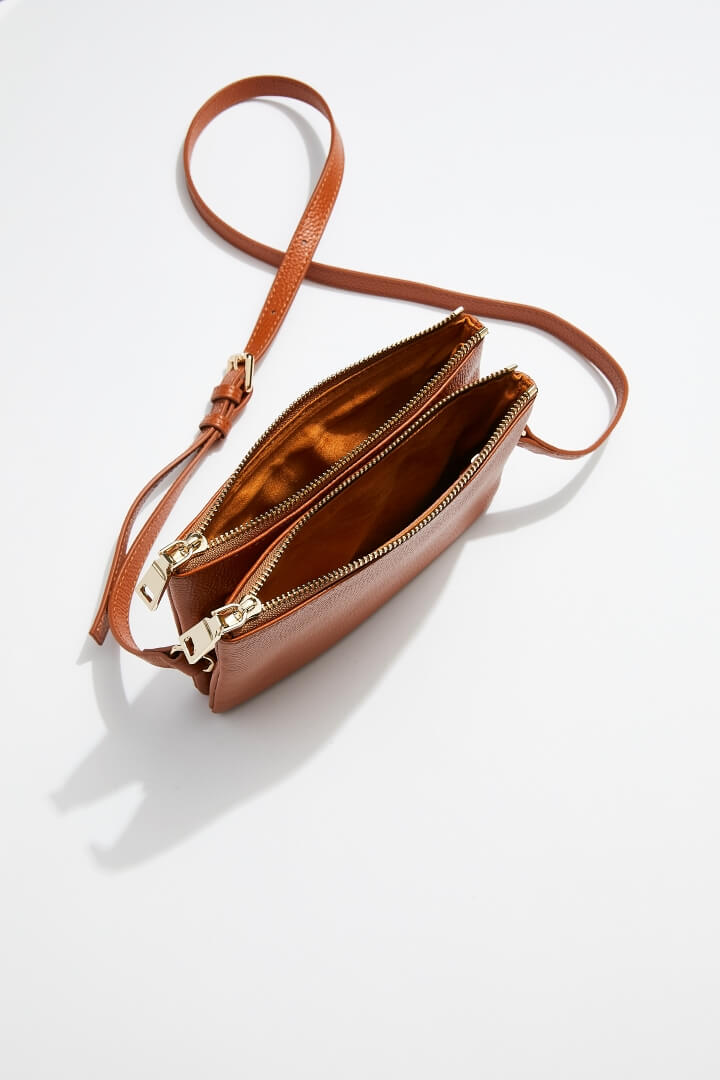 interior view of mon purses' double pouch bag in camel pebbled leather with gold hardware with long shoulder strap showing interior of both the pouches